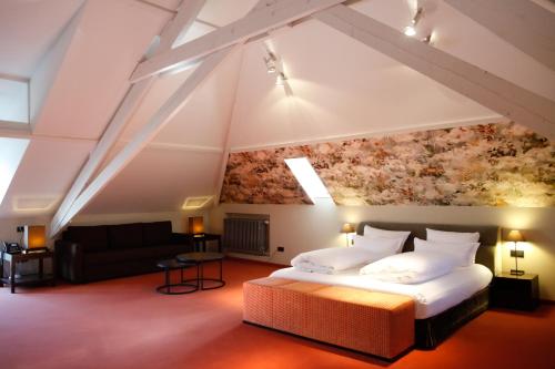 sypialnia z łóżkiem typu king-size i kanapą w obiekcie Manoir de Lébioles w mieście Spa