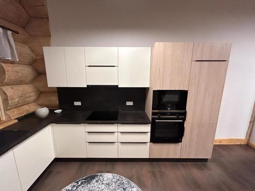 a kitchen with white cabinets and a black oven at Ferienhof Weisser Hirsch in Werben