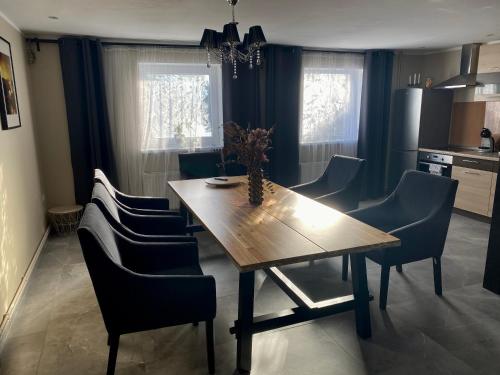 a dining room with a wooden table and chairs at PILADZI in Sigulda