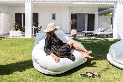 a woman sitting on an inflatable bed in a yard at Racconto Boutique Design Hotel (Adults Only) in Parga