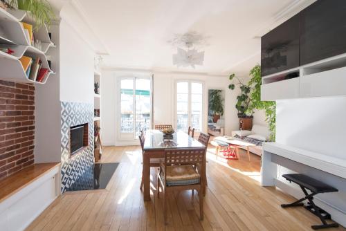 a living room with a table and a fireplace at Veeve - By the Palais Royal in Paris