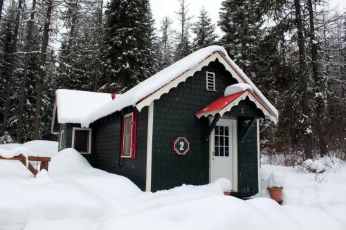 a small green house with snow on top of it at Brundage Bungalows in McCall
