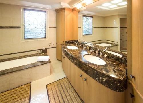 ein Badezimmer mit zwei Waschbecken und einem großen Spiegel in der Unterkunft EL PARADISIO Splendid 5 STARS Villa atypical in Antibes with overflowing swiming pool in Antibes