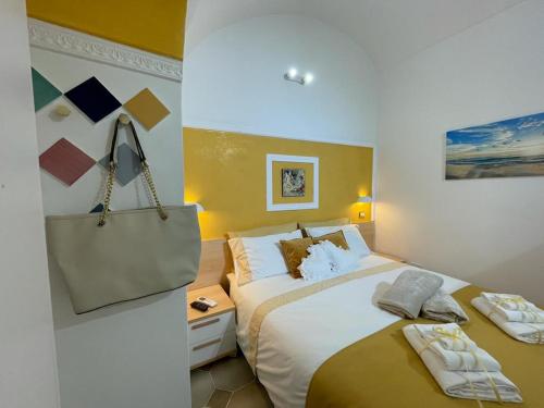 una habitación de hotel con una cama grande y un bolso en CASA ENZO con vista mare en Amalfi