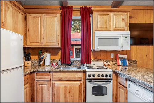 a kitchen with wooden cabinets and a white stove top oven at Brundage Bungalows in McCall