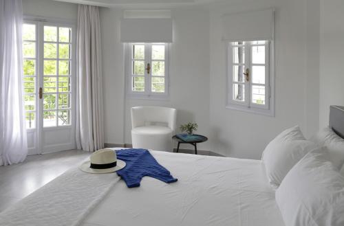 a white bed with a hat and a blue star on it at Racconto Boutique Design Hotel (Adults Only) in Parga