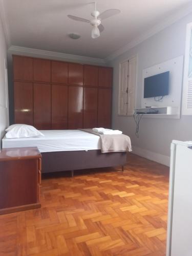 a bedroom with a large bed and a tv at Uba Apart imóveis in Ubá