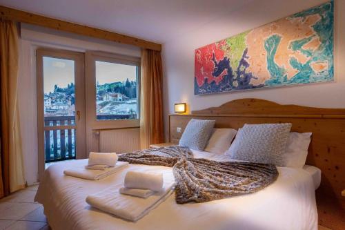 una camera da letto con un grande letto con asciugamani di Hotel Andalo ad Andalo
