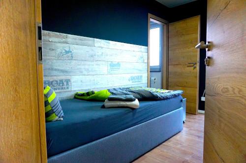 a bedroom with a blue bed with a wooden headboard at Apartment Bigler in Osloß