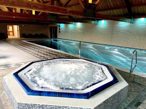 een jacuzzi in een kamer met een zwembad bij Oak Boutique Lodge includes hot tub air con & dog in York