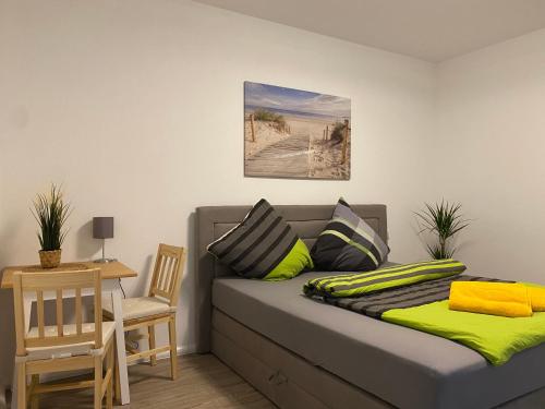 a bed in a room with a table and a chair at Pension Kirschgarten in Nebra