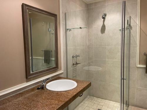 uma casa de banho com um lavatório e uma cabina de duche em vidro. em VIlla for Family and Golf em Mossel Bay