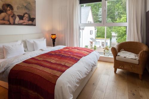 a bedroom with a large bed and a large window at GL Suites in Wiesbaden