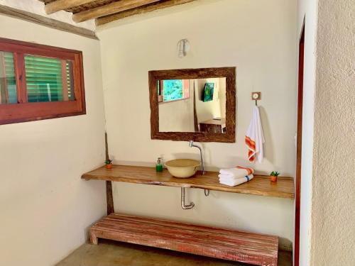 uma casa de banho com um lavatório e um espelho na parede em Prumirim Camping & Chalés em Ubatuba
