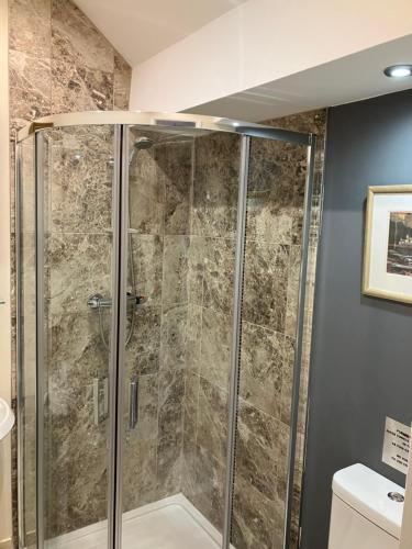 a shower with a glass door in a bathroom at THE MOUNTAIN VIEW SUITE - 2 minute walk to the lovely beach front promernade of llandudno in Llandudno