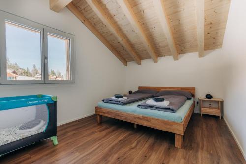 a bedroom with a bed and a flat screen tv at Chuenislodge2- zwei Balkone, gemütlicher Kamin, top Aussicht in Adelboden