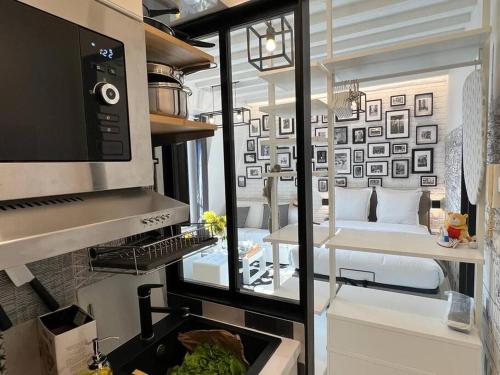 uma cozinha com vista para um quarto com uma cama em Studio tout équipé à Nation Paris XI-Tout confort em Paris