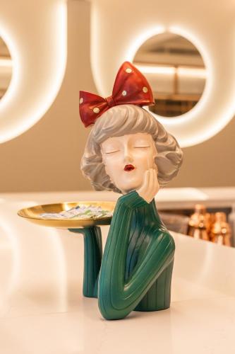 a statue of a woman with a plate on a table at LUSTER Hotel in Lisbon