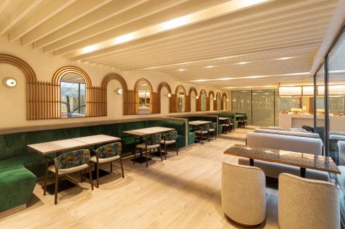 a dining room with tables and chairs and windows at LUSTER Hotel in Lisbon