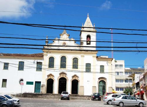 a large white building with a clock tower on top at Hostel Nossa Sra de Lourdes in Salvador