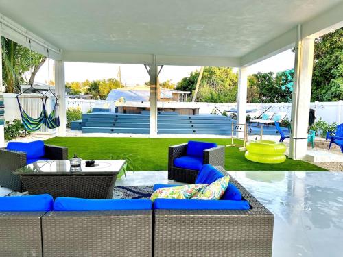 acovered patio with blue chairs and a table and a table at Casa Blue Flamingo - In the Florida Keys - minutes from the beach in Marathon