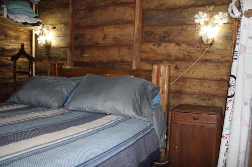 a bedroom with a bed and a wooden wall at Lomaroja ecohabs in Palmira