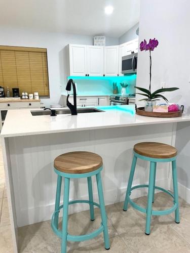 a kitchen with two blue stools and a counter at Casa Blue Flamingo - In the Florida Keys - minutes from the beach in Marathon