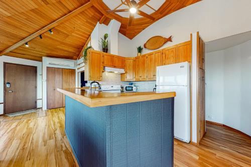 a kitchen with a blue counter top and wooden cabinets at Whidbey Moon Landing in Coupeville