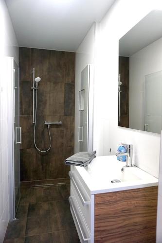 a bathroom with a white sink and a shower at Apartment Bigler in Osloß