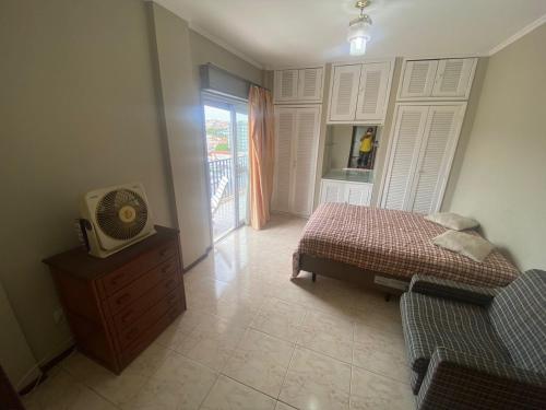 1 dormitorio con cama y vestidor con TV en Apt grande no centro de São Lourenço perto de tudo, en São Lourenço
