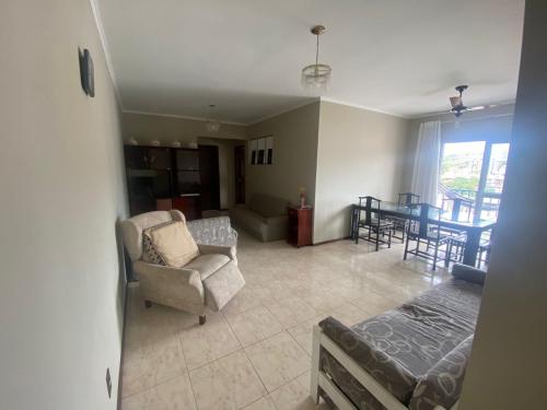 a living room with a couch and a chair and a table at Apt grande no centro de São Lourenço perto de tudo in São Lourenço