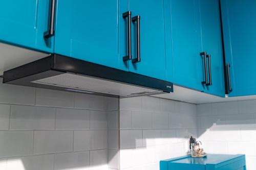 a kitchen with blue cabinets and a blue stove at PRESIDENT APARTMANI - Spa apartman, Fenix apartman, Galerija apartman in Šabac