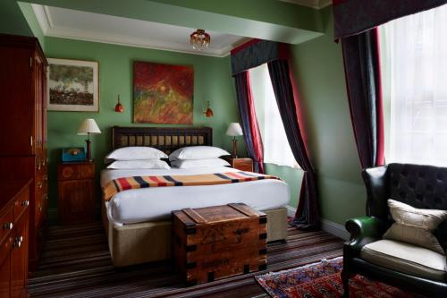 a green bedroom with a bed and a chair at The Zetter Clerkenwell in London