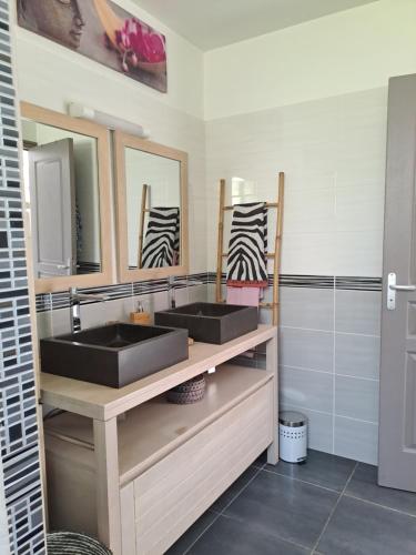 La salle de bains est pourvue de 2 lavabos et d'une douche. dans l'établissement Villa Jasmin, à Sainte-Rose