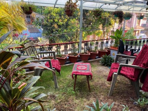 a patio with chairs and a table and potted plants at Homestay - Heaven Aumgarden in Trivandrum