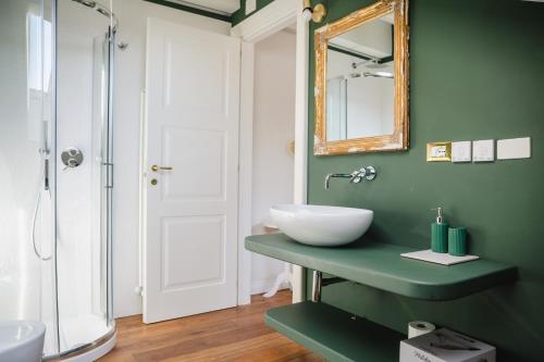 een groene badkamer met een wastafel en een spiegel bij VillaOmbrosa in Lauria Inferiore