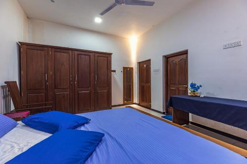 a bedroom with two beds and wooden cabinets at Villa Talpe in Talpe