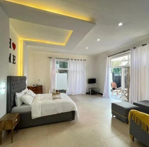 a large bedroom with a bed and a living room at Inviting 1-Bed Studio in Dar es Salaam in Dar es Salaam