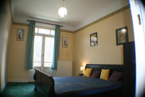 Waulsort的住宿－Echappée mosane，一间卧室配有一张带蓝色床单的床和一扇窗户。