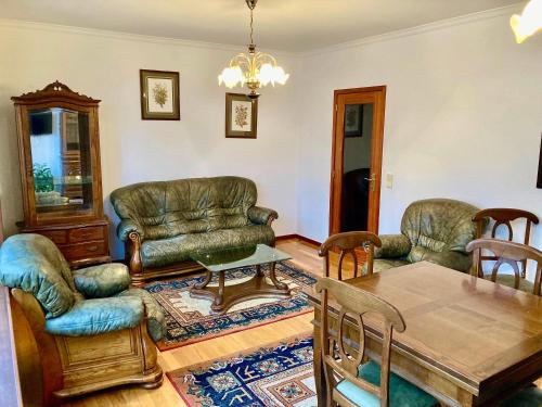 a living room with leather furniture and a table at Povoa Center Beach Apartment in Póvoa de Varzim