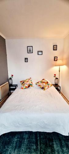 1 dormitorio con 1 cama blanca grande y 2 almohadas en Sympa Appartement avec 2 chambres séparées, en Persan