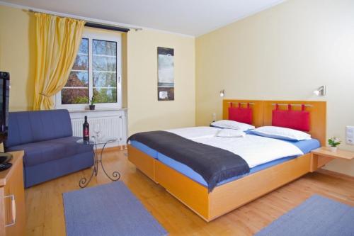 a bedroom with a large bed and a couch at Rotenberg PT Hotel in Wittlich