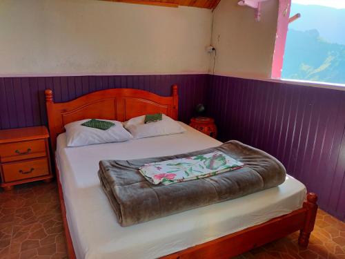 a bedroom with a bed with a wooden head board at KER L'ÎLET in Cilaos