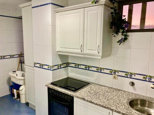 una pequeña cocina con armarios blancos y fregadero en Povoa Center Beach Apartment, en Póvoa de Varzim