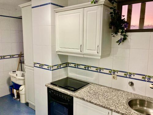 uma pequena cozinha com armários brancos e um lavatório em Povoa Center Beach Apartment na Póvoa do Varzim