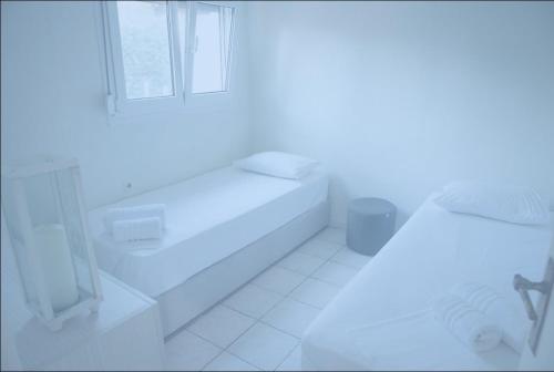 a white bathroom with a sink and a window at On the wave studios Spitakia sto kyma in Nikiti