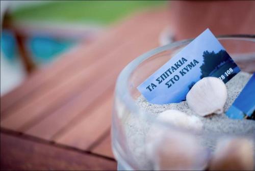 a glass container filled with sand and a small sign at On the wave studios Spitakia sto kyma in Nikiti