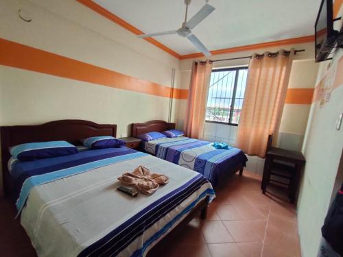 a bedroom with two beds and a window at RESIDENCIAL 14 DE DICIEMBRE in Santa Cruz de la Sierra
