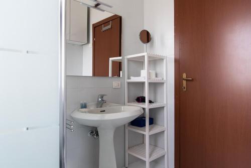W łazience znajduje się umywalka i lustro. w obiekcie YouHosty - Capecelatro 81 w Mediolanie