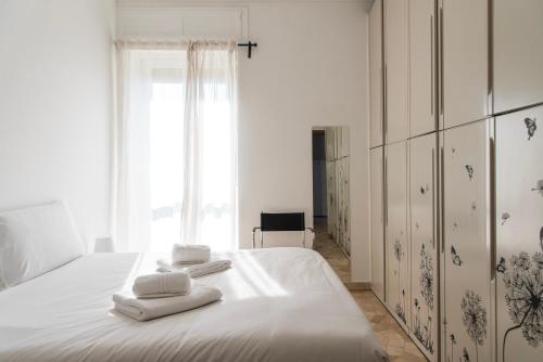 a bedroom with a white bed with towels on it at YouHosty - Capecelatro 81 in Milan
